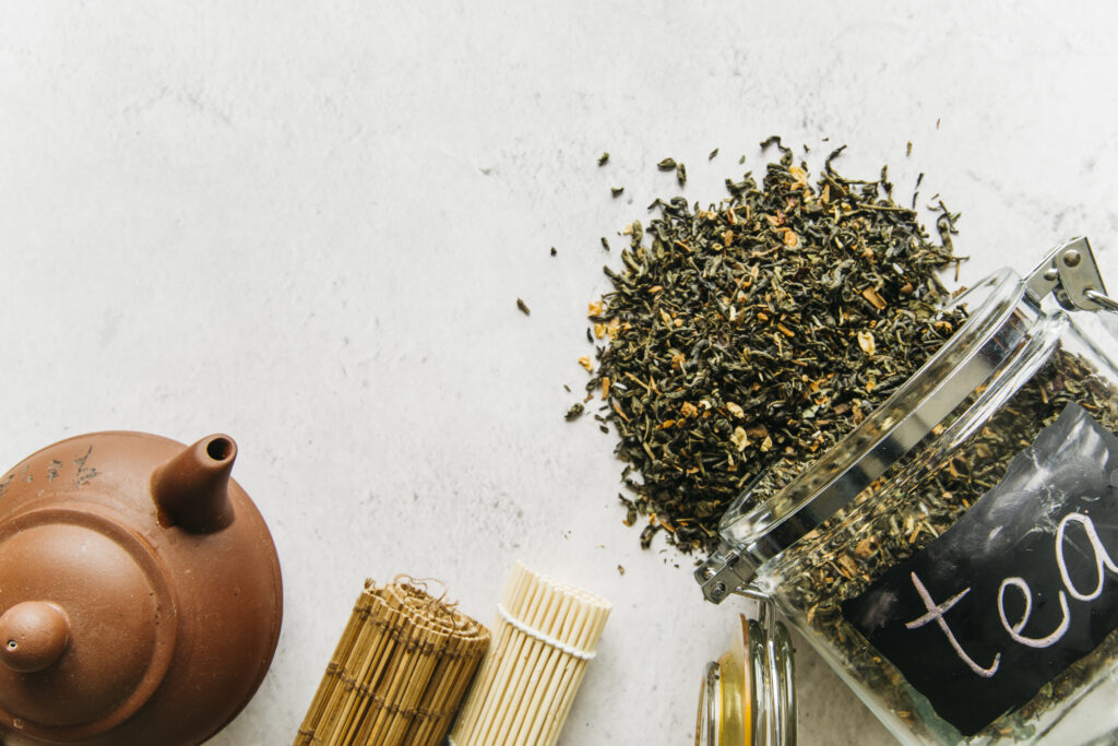 clay-teapot-rolled-up-placemat-with-spilled-dried-herbal-tea-spilled-from-glass-jar Masale Caya